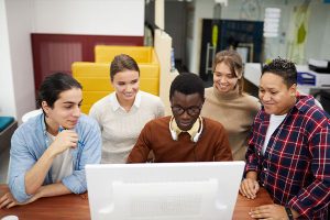Business team gathered around computer screen