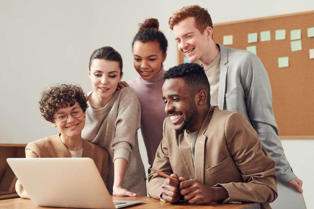 Diverse group of people staring at laptop